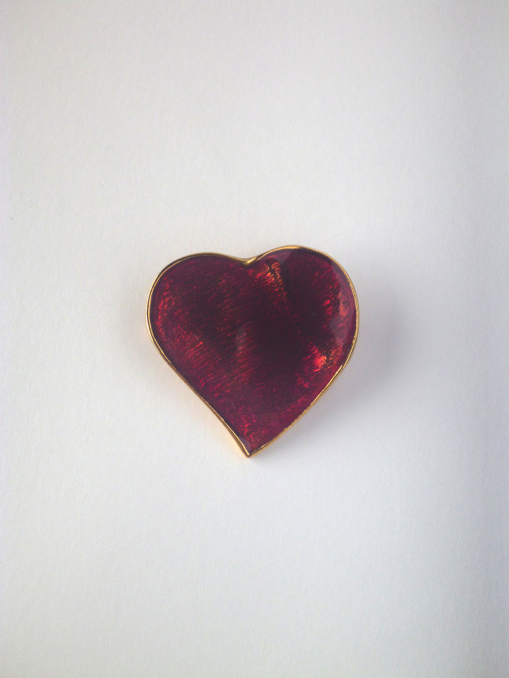 Vintage Yves Saint Laurent heart brooch featuring deep ruby-red enamel with a gold-tone trim.