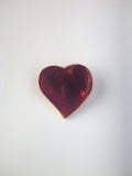 Vintage Yves Saint Laurent heart brooch featuring deep ruby-red enamel with a gold-tone trim.
