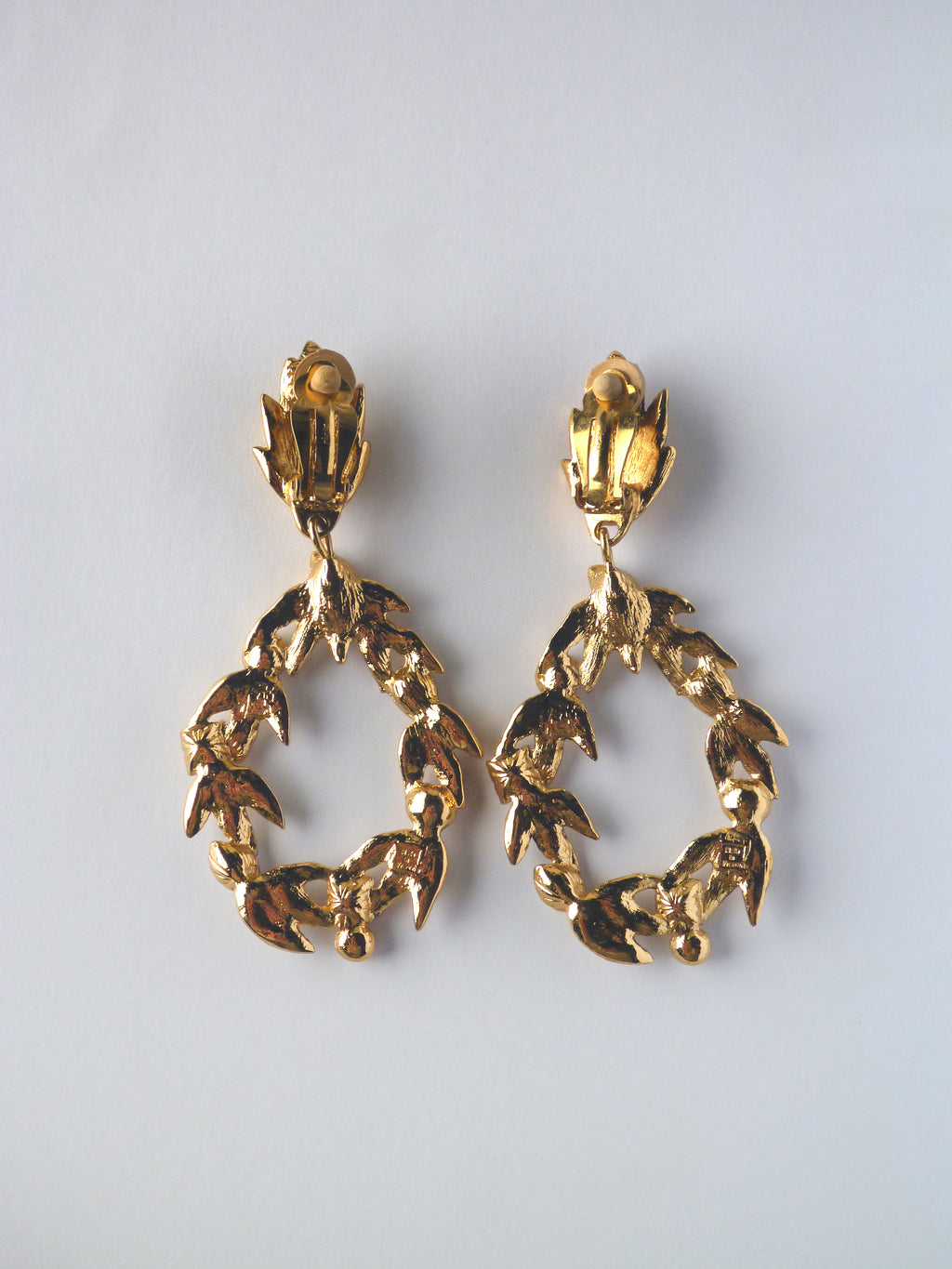 Vintage Yves Saint Laurent statement earrings featuring textured gold-tone laurel detailing and multicoloured crystal embellishments.